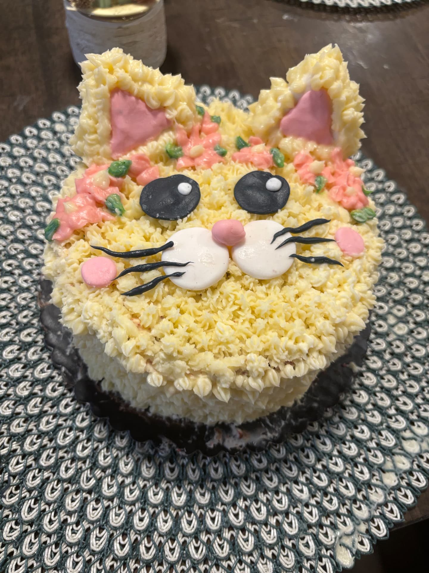 Cat shaped birthday cake decorated with piped buttercream fur, ears and whiskers